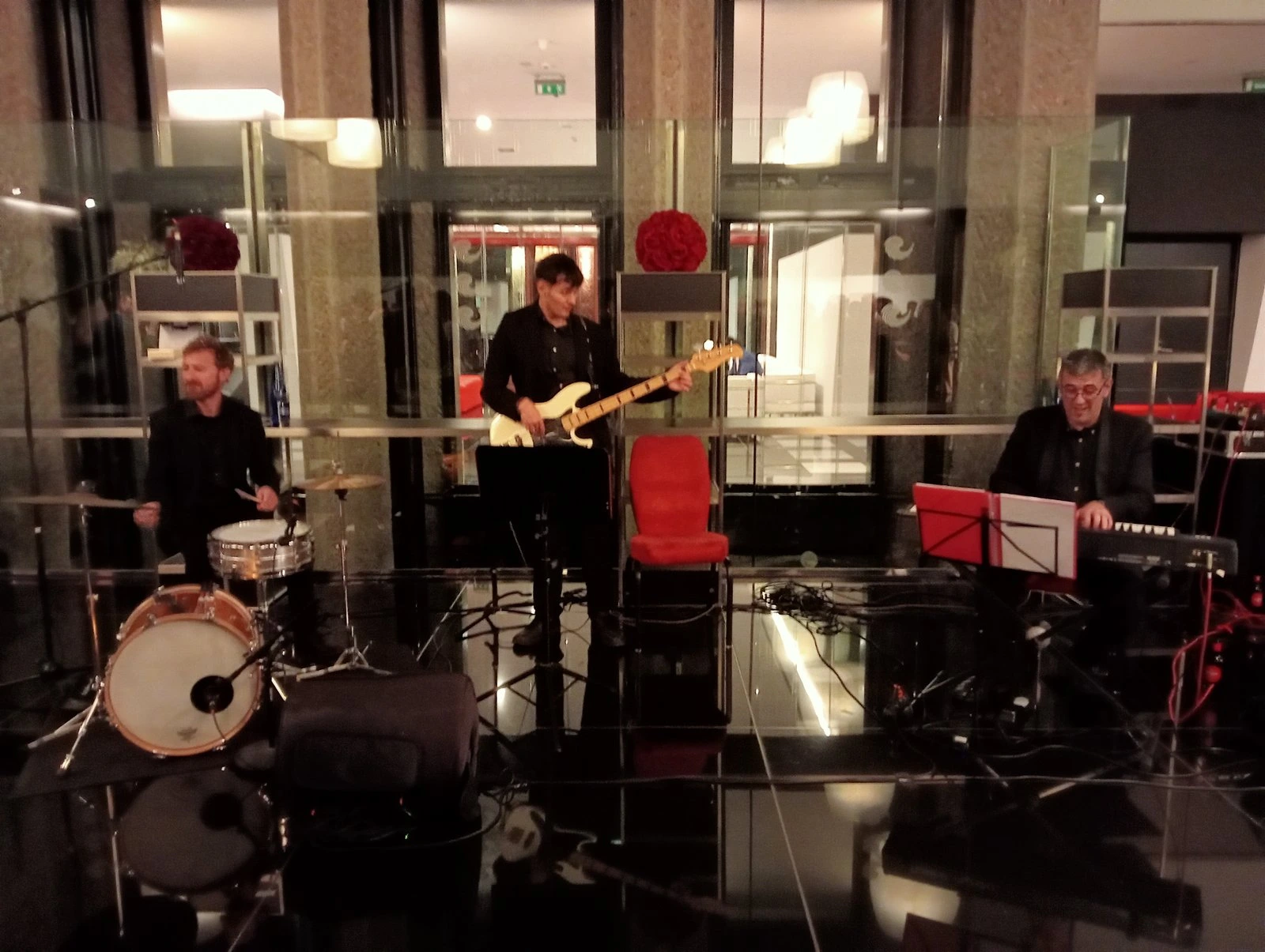 Músicos actuando en un evento con batería, guitarra y teclado