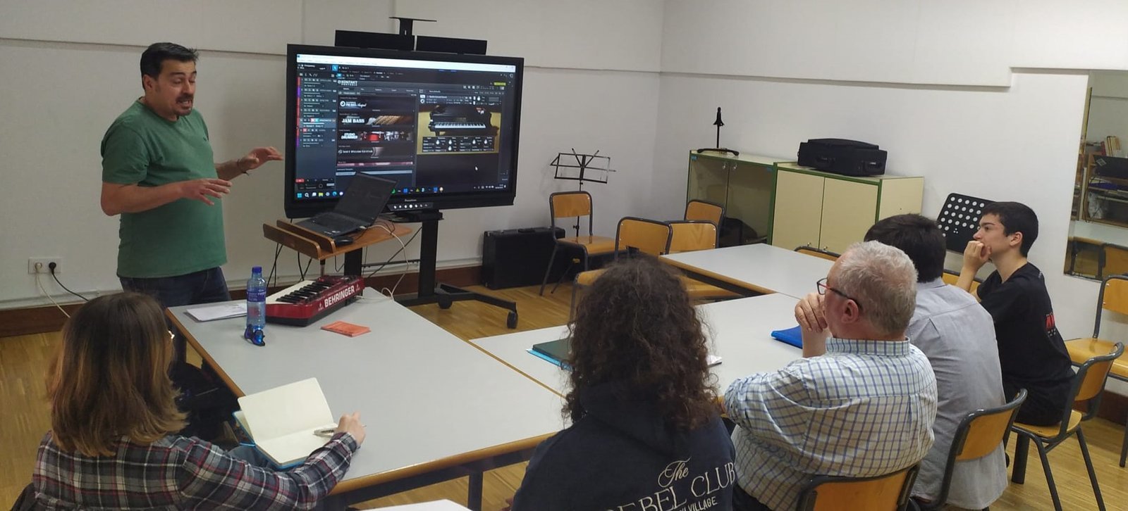 Alberto explicando producción musical a un grupo en un aula